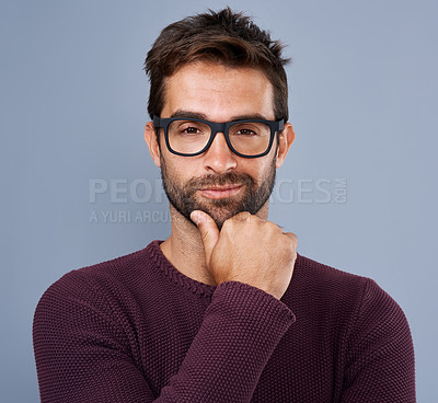Buy stock photo Studio shot of a handsome young man looking smug against a gray background