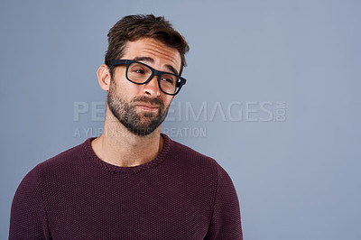 Buy stock photo Studio shot of a handsome young man looking doubtful against a gray background