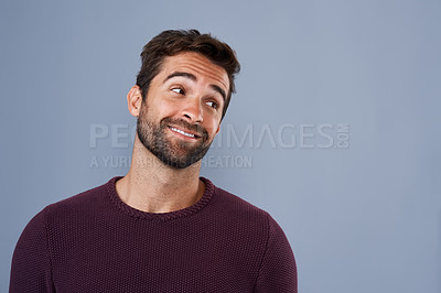 Buy stock photo Studio shot of a handsome and happy young man looking thoughtful against a gray background