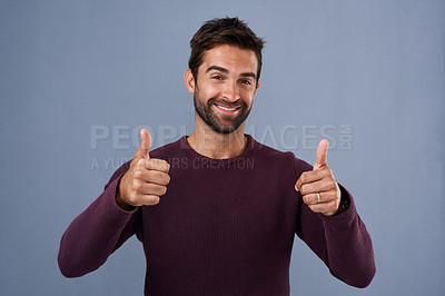 Buy stock photo Studio shot of a handsome young man giving a thumbs up gesture against a gray background