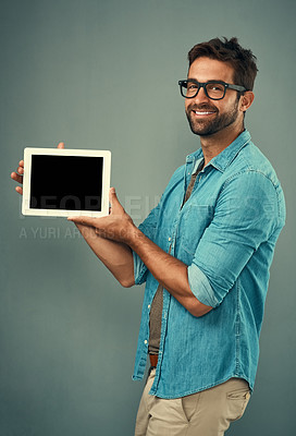 Buy stock photo Happy man, tablet and mockup screen for advertising or marketing against a grey studio background. Portrait of male person smiling and showing technology display or copy space for advertisement