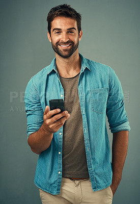 Buy stock photo Cellphone, smile and portrait of man in studio, communication and social media on gray background. Internet, online and scroll for texting on dating app, talk or happy male person on mobile for love