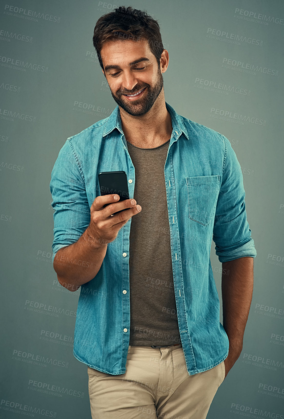 Buy stock photo Cellphone, smile and read with man in studio, communication and social media on gray background. Internet, online and scroll for texting on dating app, talk or happy male person on mobile for love