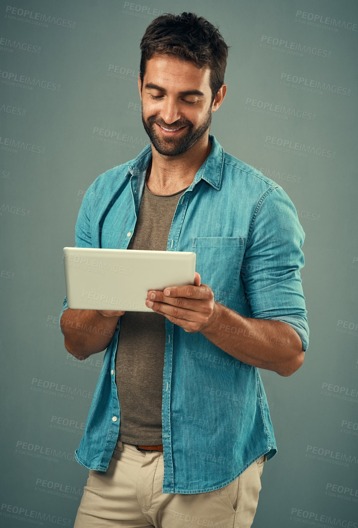 Buy stock photo Tablet, smile and studio with man online, communication and social media on gray background. Internet, online and scroll for texting on dating app, talk or happy male person on mobile for love