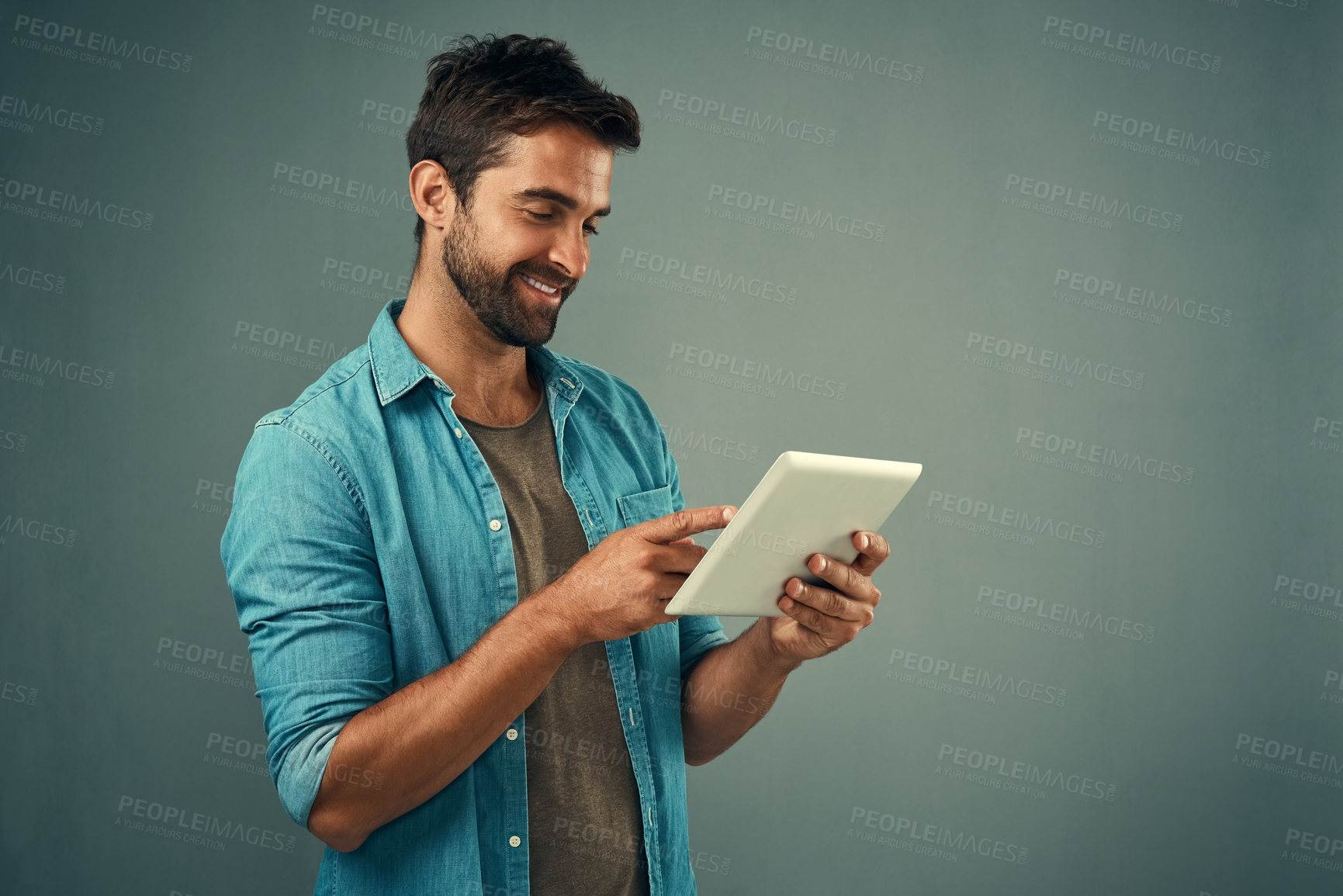 Buy stock photo Tablet, smile and studio with man online, communication and social media on gray background. Internet, online and scroll for texting on dating app, talk or happy male person on mobile for love