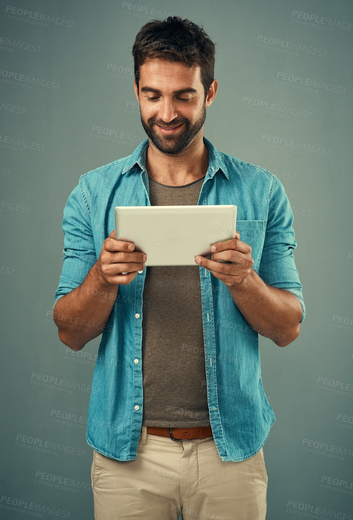 Buy stock photo Man, studio and checking with tablet and smile, career with software programming in London. Male creative, ebook and gray background with happiness for digital job, mobile app or website development