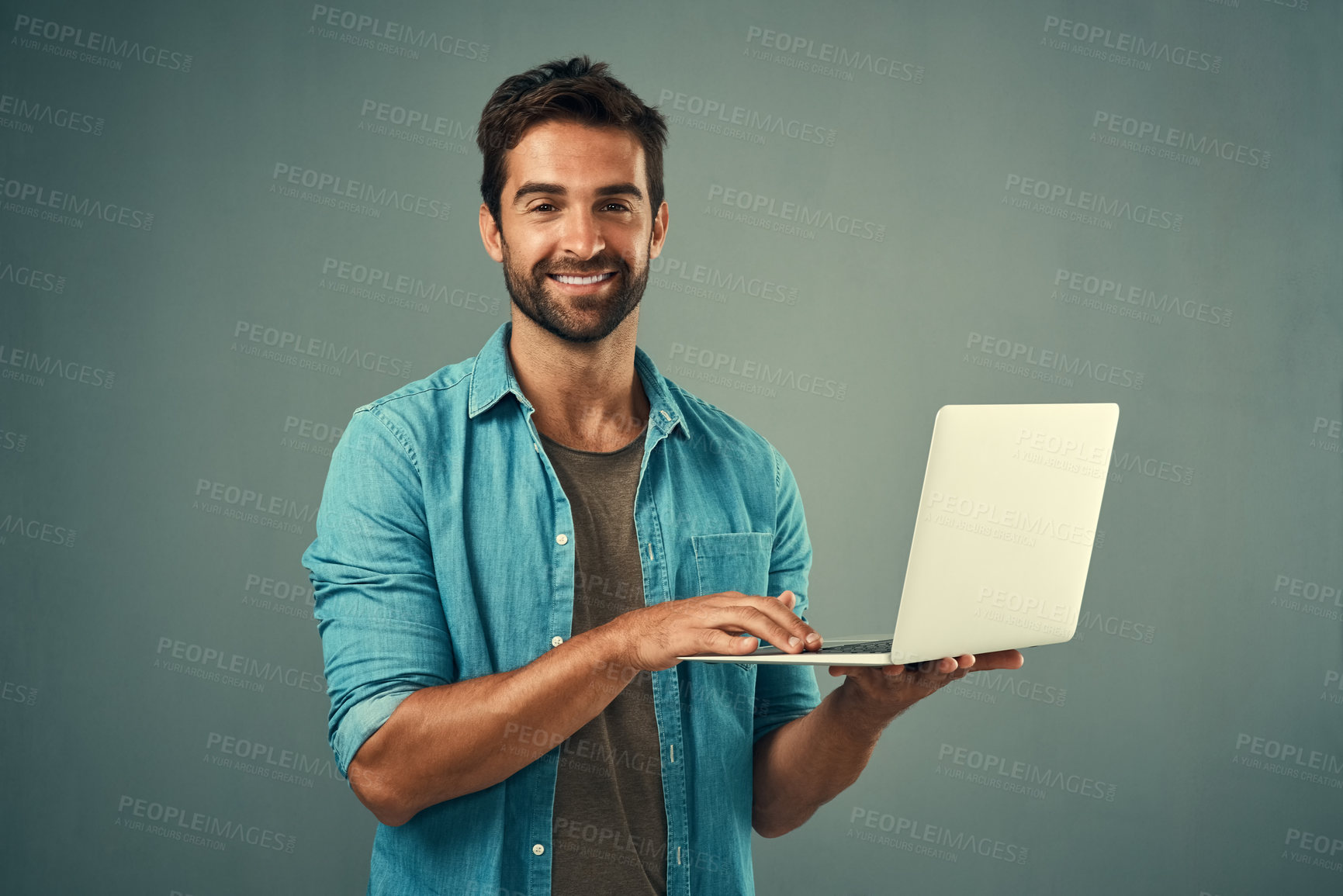 Buy stock photo Laptop, startup and portrait of man in studio with research for creative software with project development. Happy, tech and graphic designer working on multimedia art on computer by gray background.