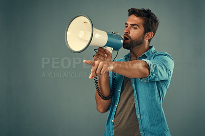 Buy stock photo Studio shot of a handsome young man talking into a megaphone against a grey background