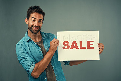 Buy stock photo Happy man, portrait and sale sign for advertising, marketing or branding against a grey studio background. Male person or realtor holding billboard or poster with smile for selling advertisement
