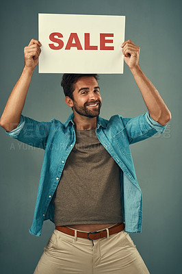 Buy stock photo Happy man, sale and billboard poster for advertising, marketing or branding against a grey studio background. Male person or realtor holding board or sign for sales announcement or advertisement