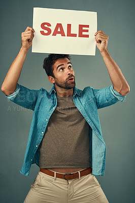 Buy stock photo Man, hands and sale on poster for advertising, marketing or branding against a grey studio background. Male person or realtor holding board, sign or billboard for sales announcement or advertisement