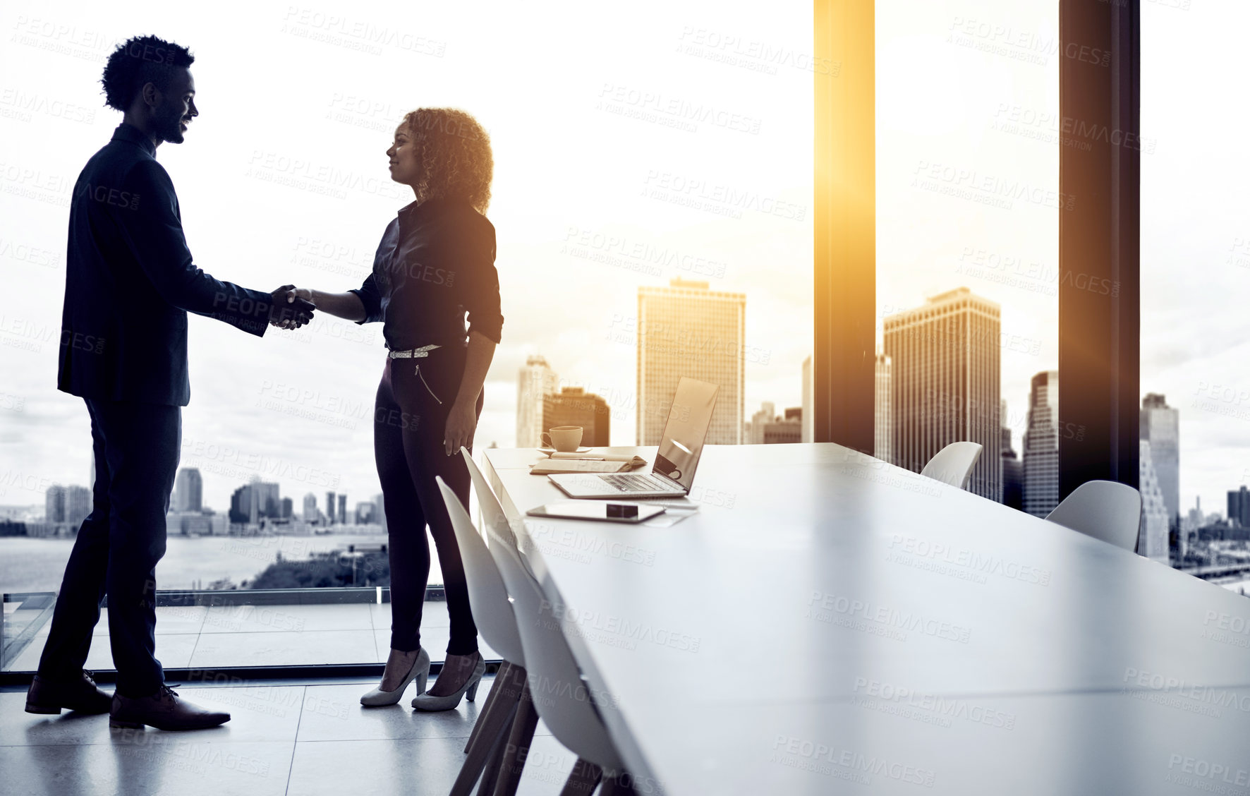 Buy stock photo Shot of two businesspeople shaking hands in an office