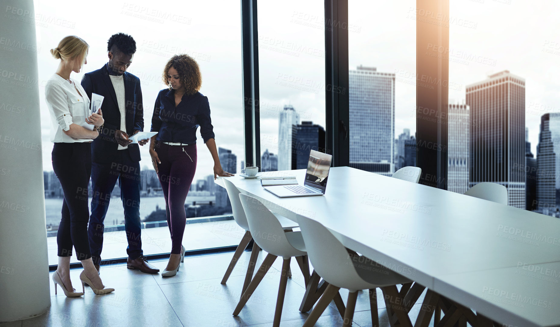 Buy stock photo Shot of a group of businesspeople working together on a digital tablet in an office