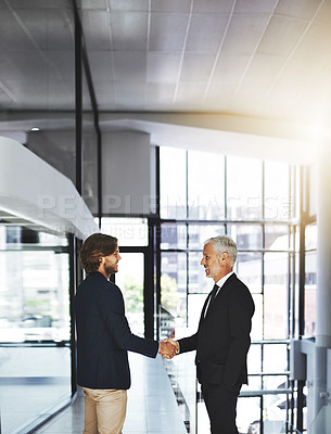 Buy stock photo Cropped shot of two businessmen shaking hands in an office