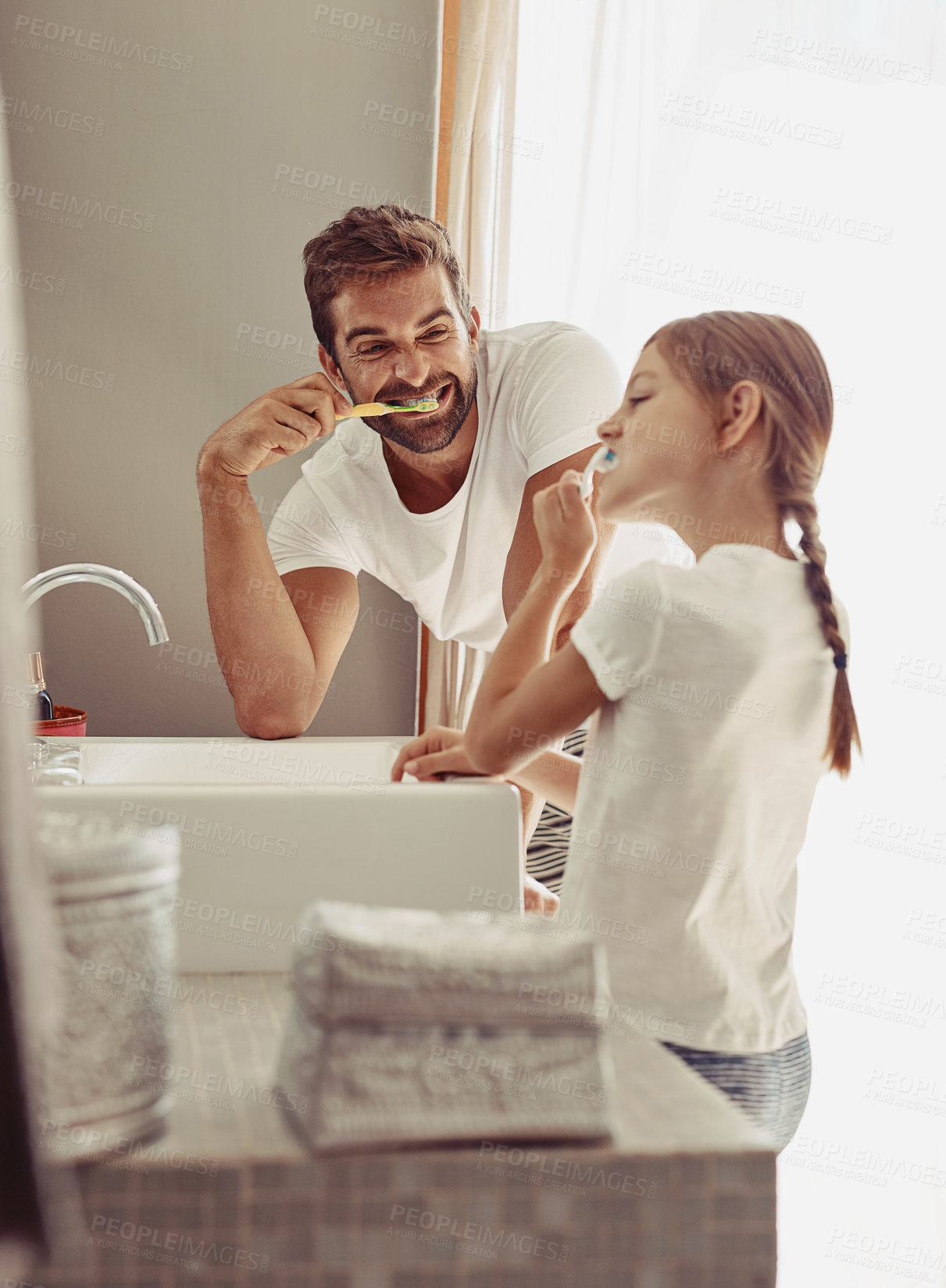Buy stock photo Shot of a happy father and his little girl washing their hands together in the bathroom
