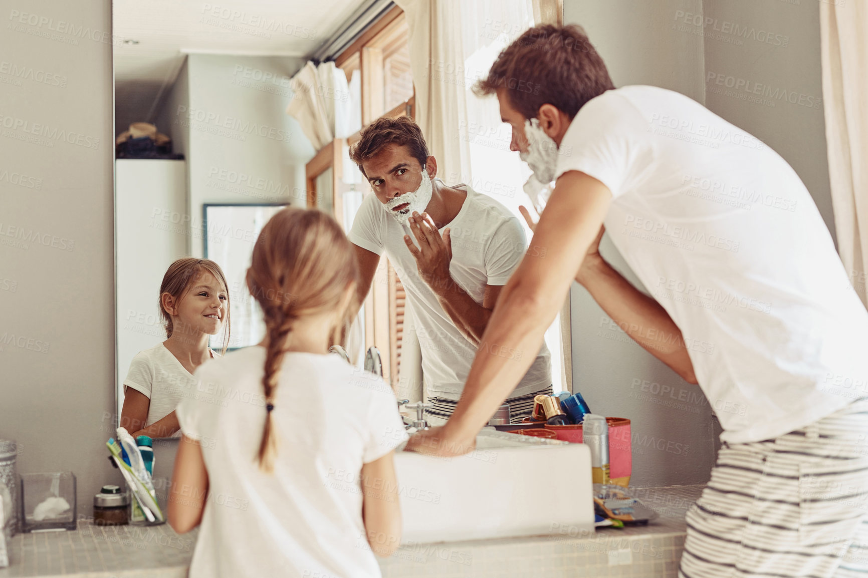 Buy stock photo Shot of a happy little girl watching her father as her shaves by the sink
