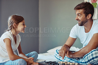 Buy stock photo Shot of a man playing a board game with his little girl at home