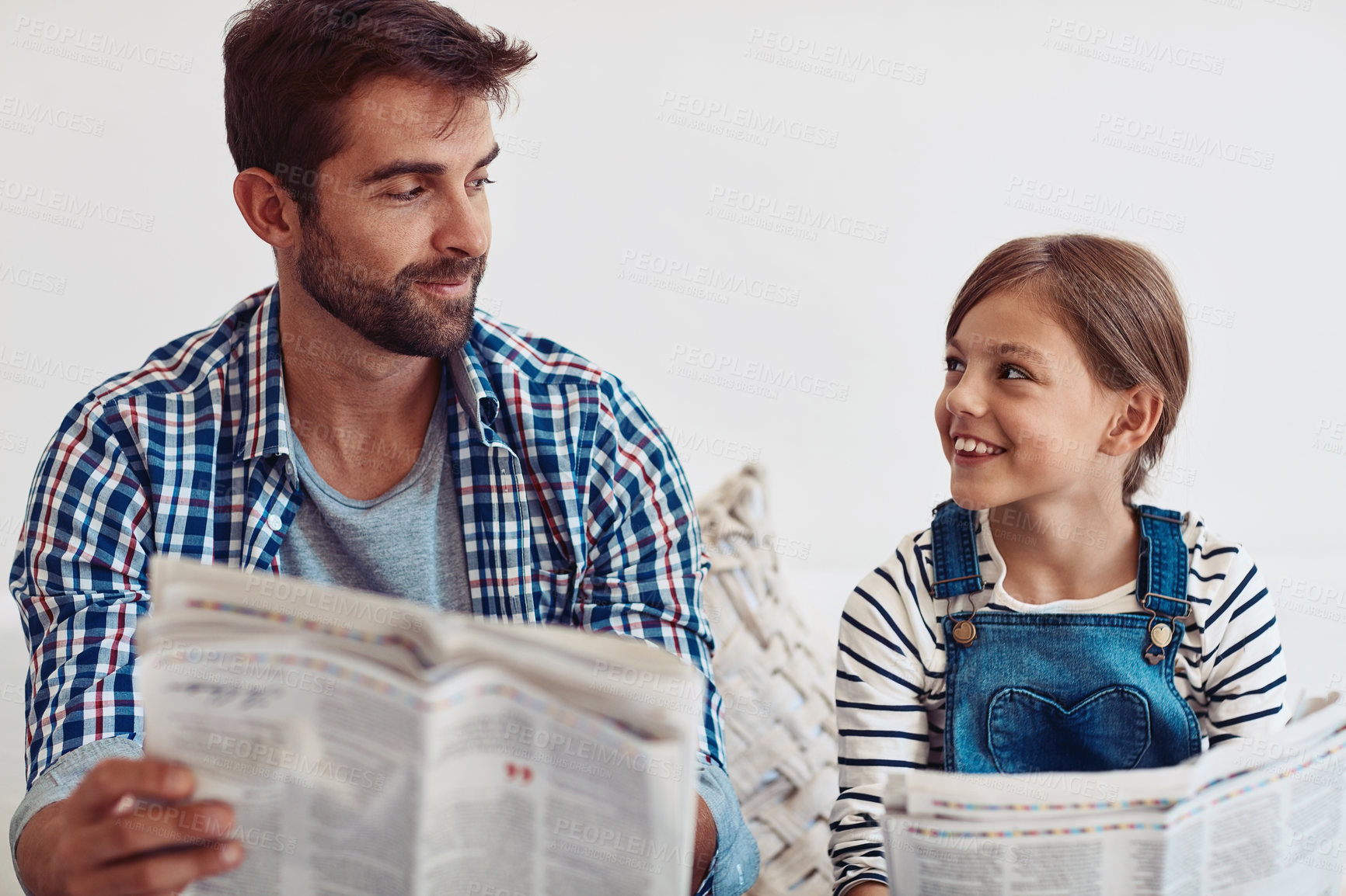 Buy stock photo Dad, girl and reading newspaper on sofa in home with smile, learning or update for global event. Man, father and child with press, media and check for headlines, story or bonding in family house