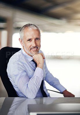 Buy stock photo Cropped portrait of a handsome and mature businessman sitting in his office