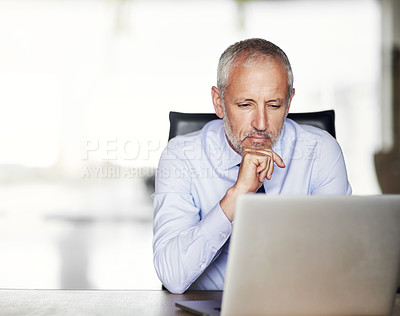 Buy stock photo Cropped shot of a handsome and mature businessman working on his laptop