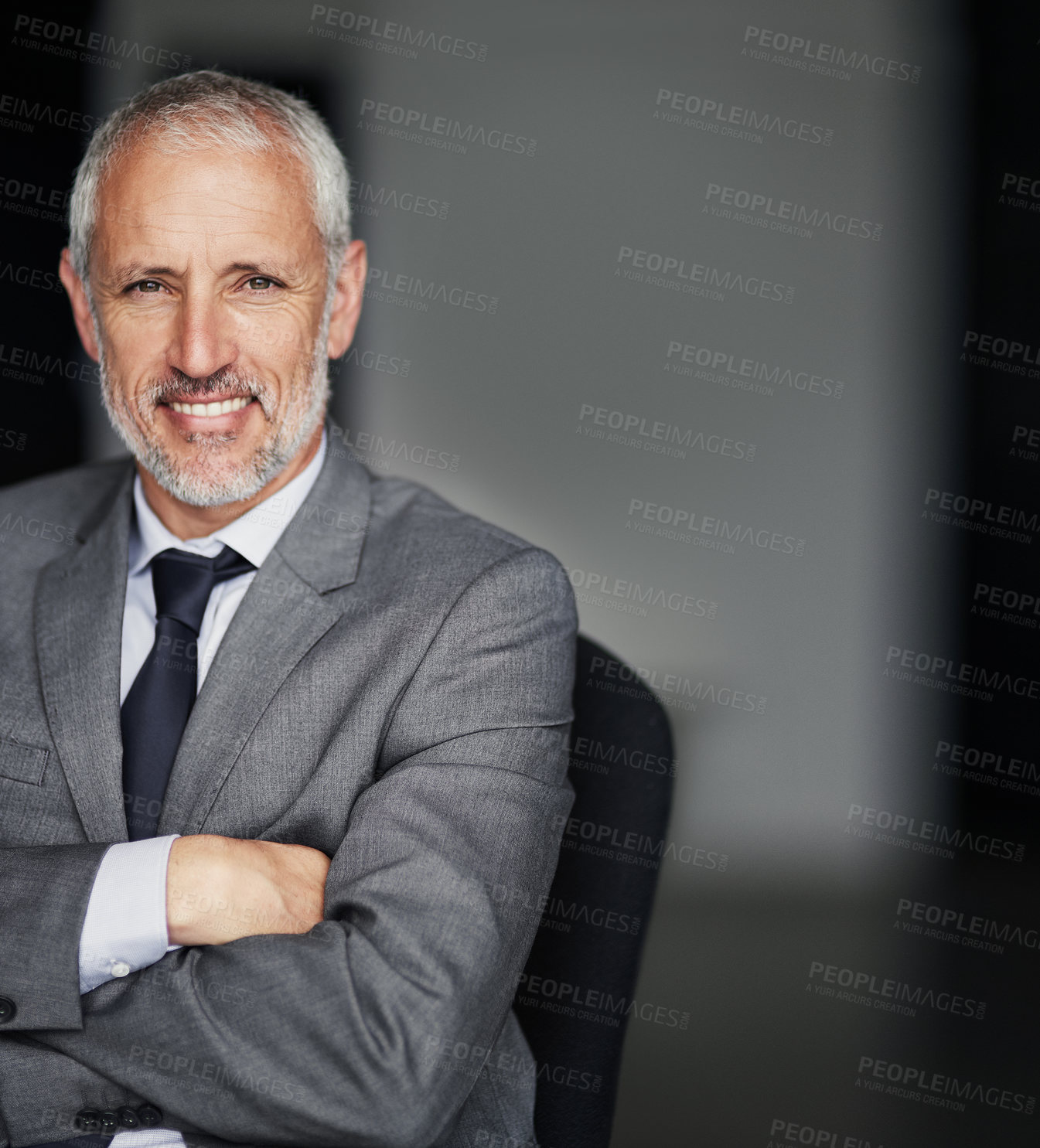 Buy stock photo Cropped portrait of a mature businessman sitting down with his arms crossed