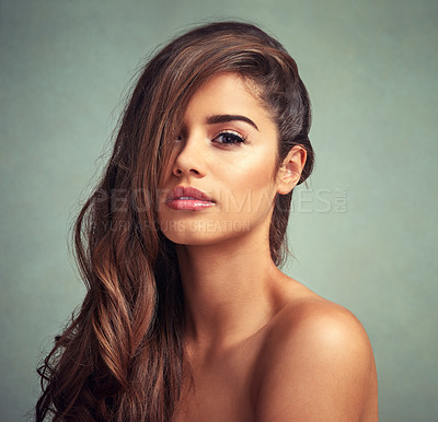 Buy stock photo Studio portrait of a beautiful woman with long locks posing against a grey background
