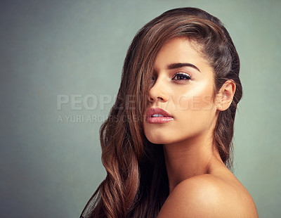 Buy stock photo Studio shot of a beautiful woman with long locks posing against a grey background