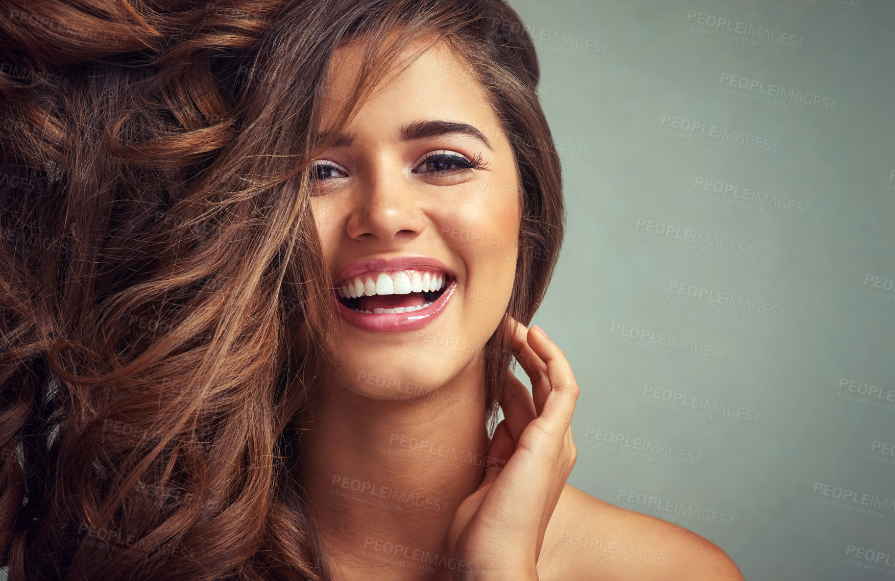 Buy stock photo Studio portrait of a beautiful woman with long locks posing against a grey background