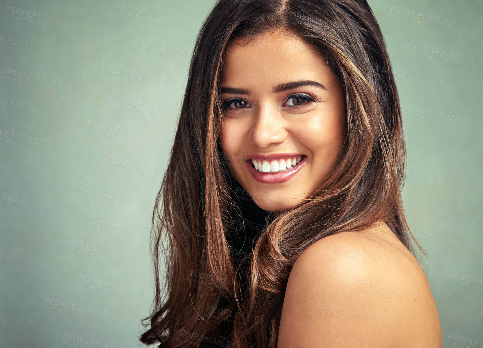 Buy stock photo Studio portrait of a beautiful woman with long locks posing against a grey background