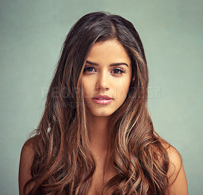 Buy stock photo Studio portrait of a beautiful woman with long locks posing against a grey background