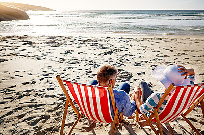 Buy stock photo Shot of a mature couple relaxing on beach chairs