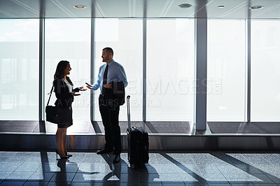 Buy stock photo Shot of two businesspeople talking together in an airport