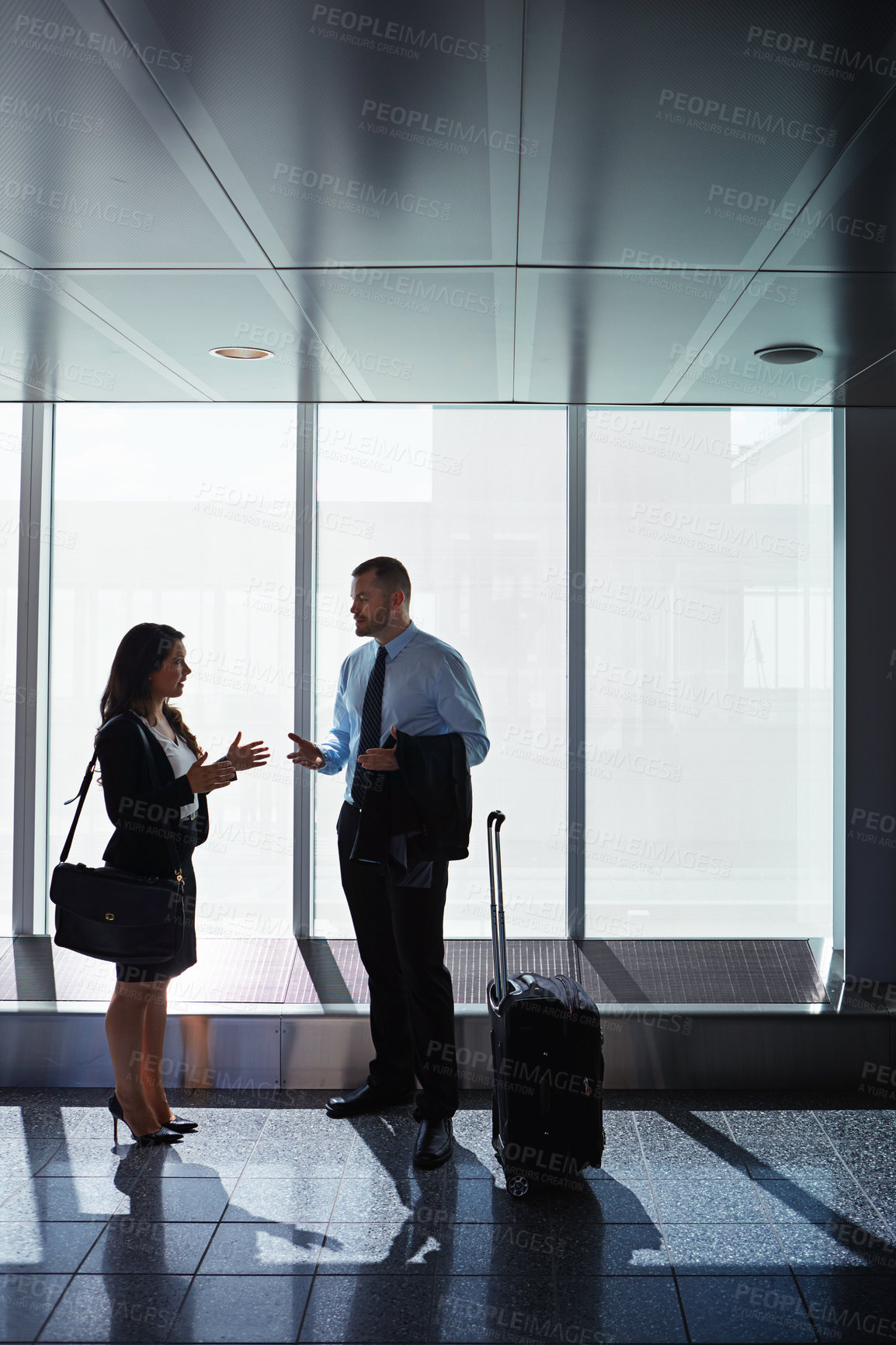 Buy stock photo Shot of two businesspeople talking together in an airport