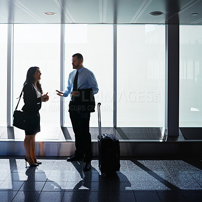 Buy stock photo Shot of two businesspeople talking together in an airport