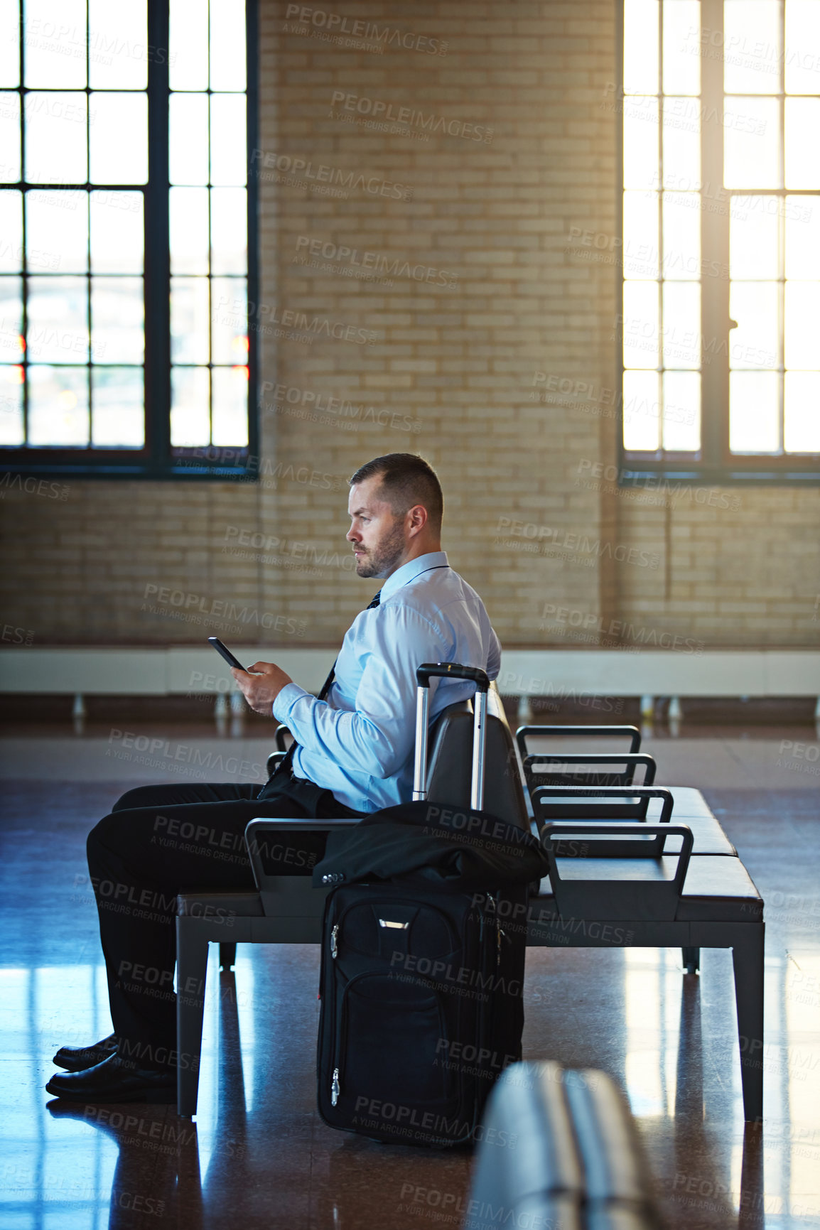 Buy stock photo Luggage, phone and thinking with businessman in train station for commute or trip to work location. App, space and suitcase with employee person waiting in terminal for public transport or travel