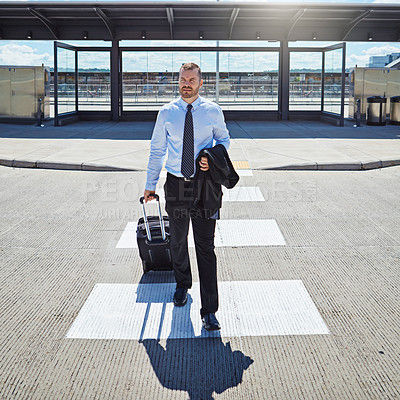 Buy stock photo Shot of a professional businessman walking toward an airport with his luggage