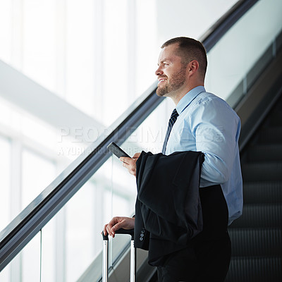 Buy stock photo Shot of a businessman traveling down an escalator in an airport