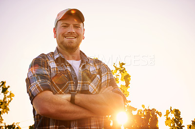 Buy stock photo Portrait of a happy farmer posing with his arms crossed in a vineyard