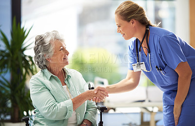 Buy stock photo Shot of a doctor shaking hands with a smiling senior woman sitting in a wheelchair