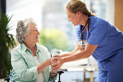 Buy stock photo Shot of a doctor shaking hands with a smiling senior woman sitting in a wheelchair