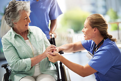 Buy stock photo Shot of a doctor holding hands with a senior woman in a wheelchair