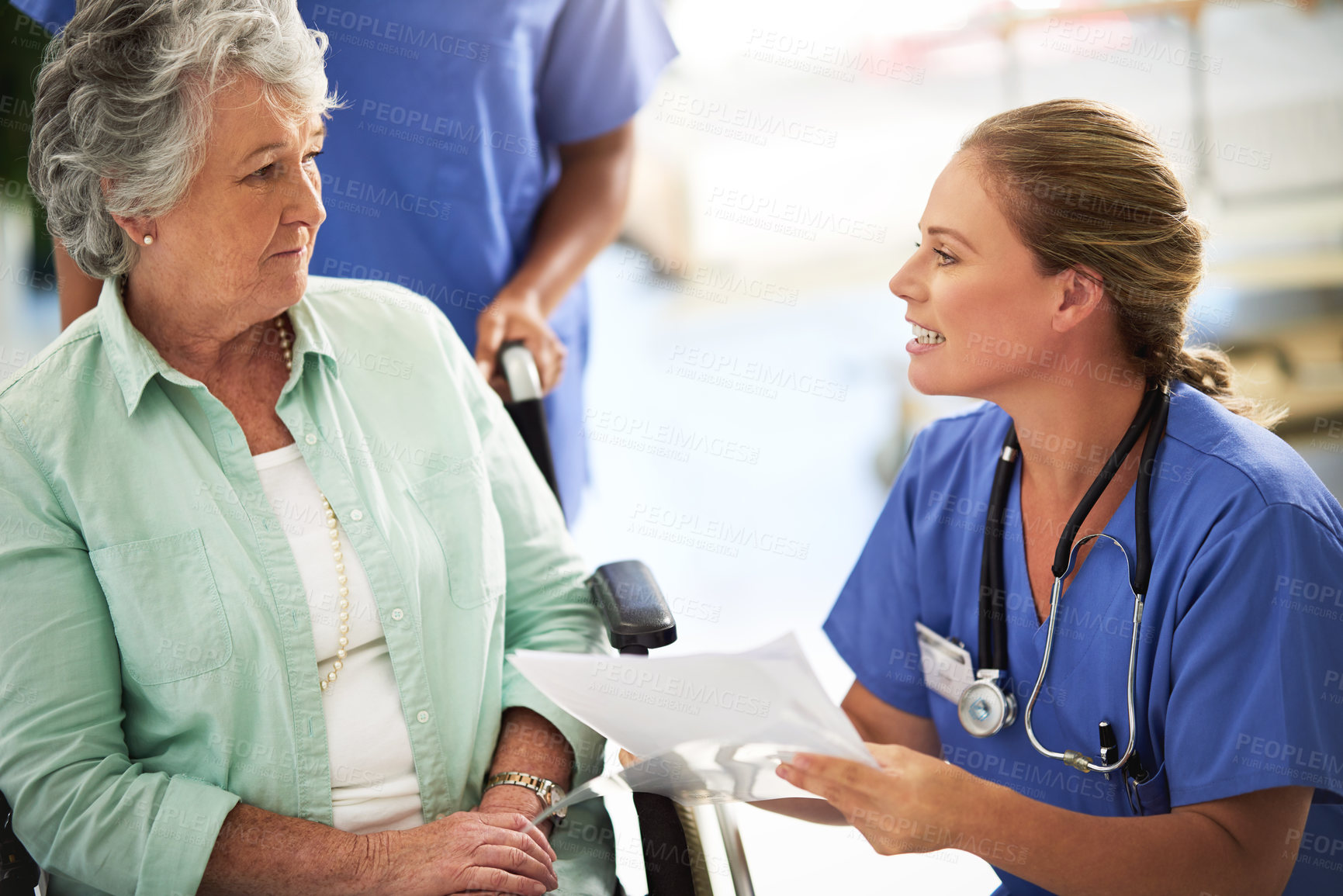Buy stock photo Shot of a doctor discussing treatments with a senior woman sitting in wheelchair in a hospital