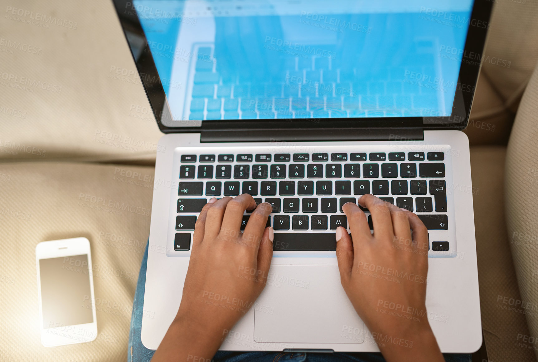 Buy stock photo Cropped shot of a woman using her laptop on the sofa at home