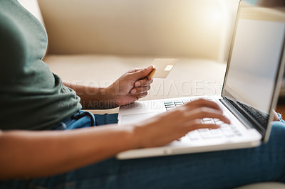 Buy stock photo Cropped shot of a woman using her laptop on the sofa at home