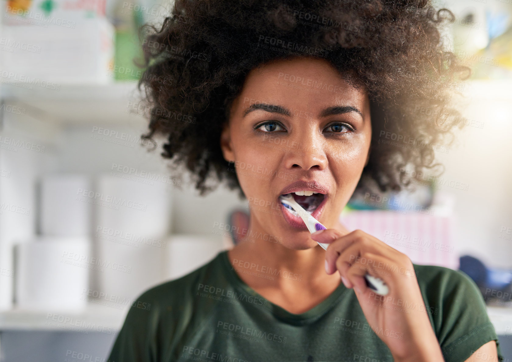 Buy stock photo Shot of a young woman brushing her teeth in her bathroom