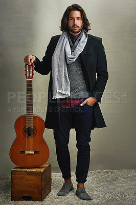 Buy stock photo Portrait of a stylishly dressed man posing with a guitar in the studio