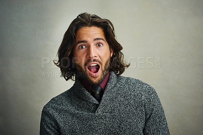 Buy stock photo Portrait of a stylishly dressed man looking surprised against a gray background in the studio