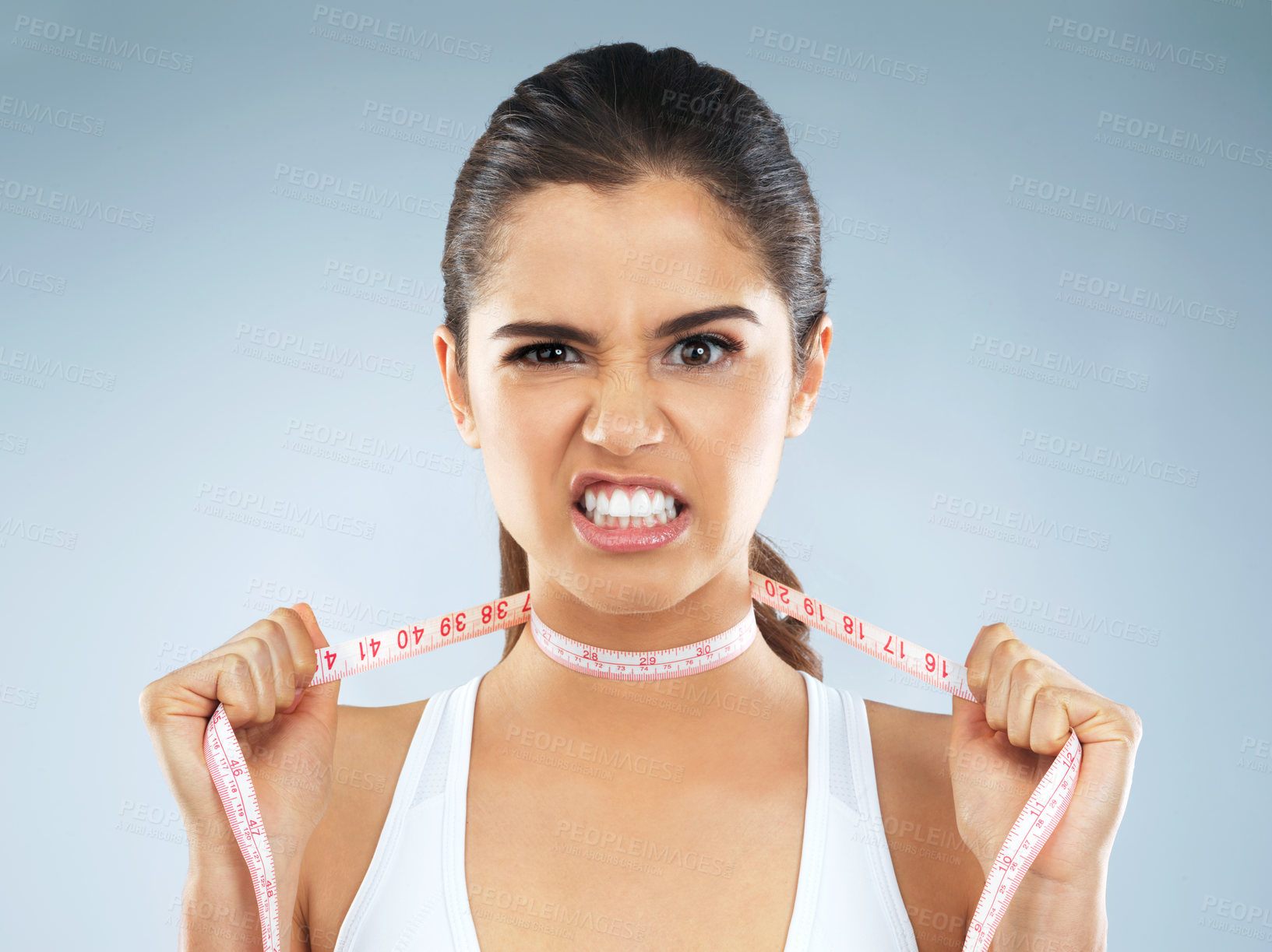 Buy stock photo Angry, woman and portrait with measure tape and choke from difficult diet, weight loss issue and body standards. Frustrated, problem and upset from society expectations in studio with blue background