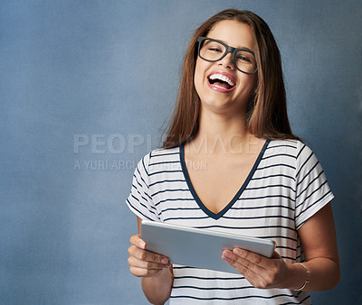 Buy stock photo Studio shot of a young woman using her digital tablet against a grey background