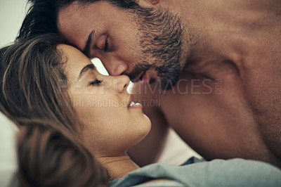 Buy stock photo Cropped shot of an affectionate young couple being intimate in bed